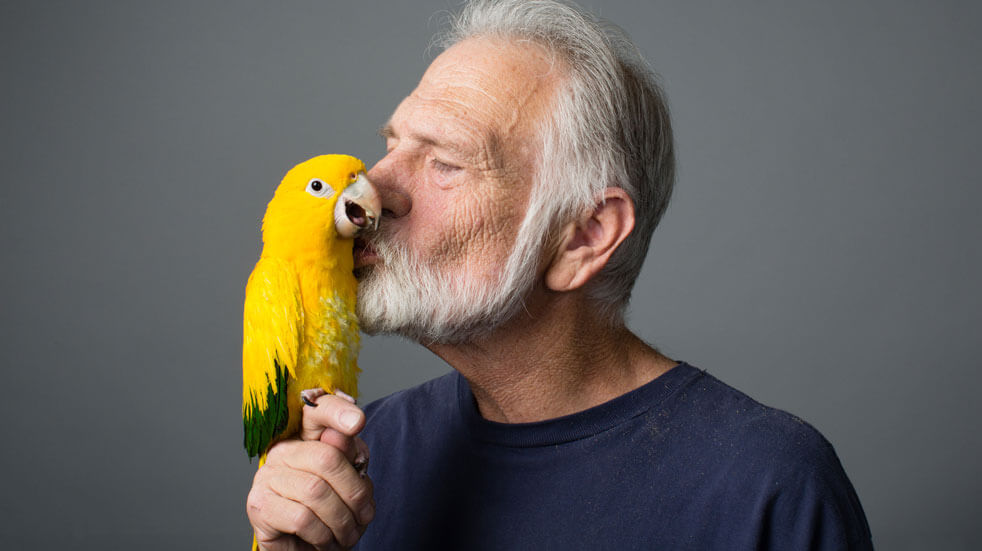 Why having pets could change your life; man with parrot